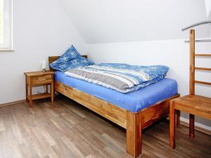 a bedroom with a bed with blue sheets and a table at Haus in Vieregge am Breetzer Bodden in Vieregge