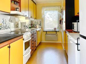 a yellow kitchen with white appliances and a window at 6 person holiday home in BORGHOLM-By Traum in Borgholm