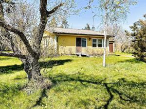 a yellow house in a field with a tree at Rural House with Garden Near Borgholm in Borgholm +11 photos