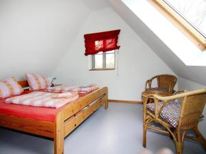 a bedroom with a bed and a window and a chair at Ferienhaus im Hafendorf Vieregge in Vieregge