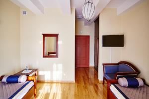a living room with two beds and a tv at Centrum Obsługi Turysty Kordegarda in Raczki