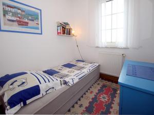 a small bedroom with a bed and a blue dresser at Holiday Bungalow in Dornumersiel in Dornumersiel