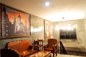 a dining room with a table and chairs and a picture at Old City Boutique House in Sukhothai