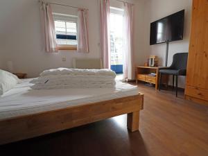 a bedroom with a bed with a television and a chair at Doppelhaushälfte Bernsteinhaus II, Trassenheide in Trassenheide