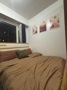 a bed in a bedroom with pictures on the wall at Shore Residences Pool View Room near MOA and NAIA in Sampong