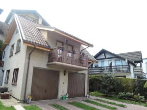 a house with a balcony and two garage doors at Mi dzyzdroje Terraced House near Promenade in Międzyzdroje