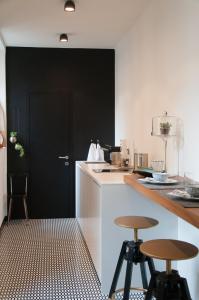 a kitchen with two bar stools and a black door at Suite Juvara in Como