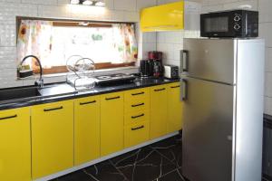a kitchen with yellow cabinets and a refrigerator at Seaside Holiday Home winouj cie in Świnoujście