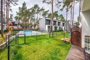 un cortile con piscina e parco giochi di Pobierowo Holiday Home near Baltic a Pobierowo
