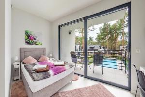 una camera con letto e un balcone con piscina di Pobierowo Holiday Home near Baltic a Pobierowo