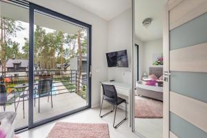 una stanza con balcone con scrivania e camera da letto di Pobierowo Holiday Home near Baltic a Pobierowo
