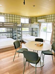 a room with two bunk beds and a table and chairs at Vivo House Hakomatsu - Apartment Stay in Fukuoka