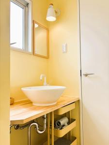 a bathroom with a white sink and a mirror at Vivo House Hakomatsu - Apartment Stay in Fukuoka +39 photos