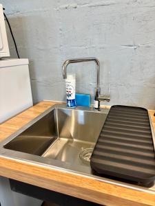 a stainless steel kitchen sink with a tray on it at Vivo House Hakomatsu - Apartment Stay in Fukuoka