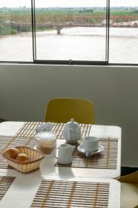 a table with a tea set with a view of a river at Hotel RUAH TUMBES in San Antonio