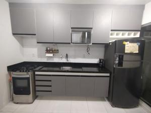 a small kitchen with a sink and a refrigerator at Casa em condomínio COP 30 in Ananindeua