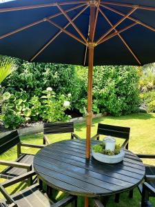 a blue table with an umbrella on a patio at Tree View Studio in Tauranga
