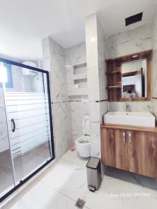 a bathroom with a toilet and a sink and a shower at Leboss Meublé in Yaoundé