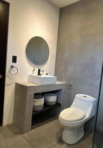 a bathroom with a toilet and a sink and a mirror at Casa Luna in Santa Cruz