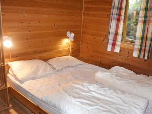 un letto in una stanza con una parete di legno di 6 person holiday home in Bud-By Traum a Bud
