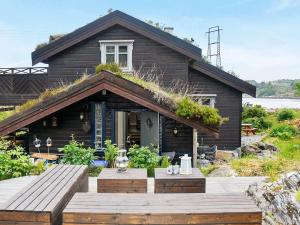 a house with a wooden deck in front of it at 8 person holiday home in FREI in Frei