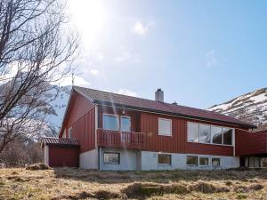 una casa rossa con balcone su una collina di 6 person holiday home in LAUPSTAD-By Traum a Laupstad