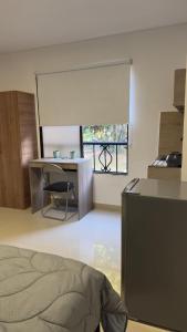 Una habitación con una cama y un escritorio y una ventana. en Venezia 208, en Cali
