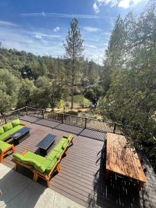 a deck with chaise lounges and chairs on it at Beautiful Lake Views with Hot Tub and Space for Family in Oakhurst