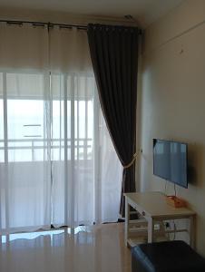 ポートディクソンにあるseaview beach homestay pdのリビングルーム(テレビ、テーブル、窓付)