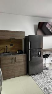 カリにあるVenezia 202のステンレス製の冷蔵庫とシンクを備えたキッチン