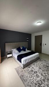 カリにあるVenezia 202の青い枕が付いた大きなベッドのある寝室