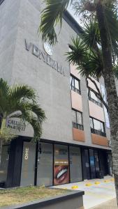 カリにあるVenezia 202のヤシの木が前に立つベランダの建物