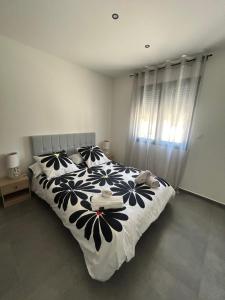 a bedroom with a bed with a black and white comforter at Villa house 120m2 4 chambre 4 lit double in Les Tourrettes