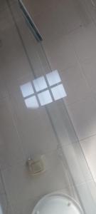 a bathroom with a toilet and lights on the ceiling at Charmosa Casa de Madeira a 700 metros da praia in Rio das Ostras +12 photos