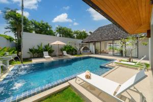 una imagen de una piscina en una villa en Anchan Villas Phuket - 4 BR Signature Pool Villa by Escape Villas, en Ban Phru Champa