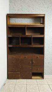 Una estantería de madera con cajones y una pared. en Hostal casa el calvarito, en León 2 fotos más