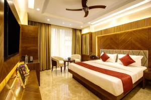 a hotel room with a bed and a television at The Vanson Pride in New Delhi
