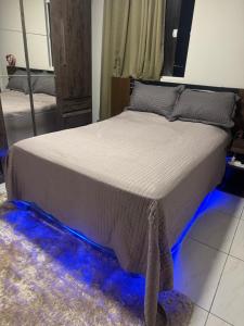 a bed with blue lights on the floor in a bedroom at Apartamento moderno e aconchegante com ótima localização in Campina Grande