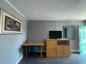 a room with a desk with a television and a desk sidx sidx sidx at Budget Inn Port Lavaca in Port Lavaca