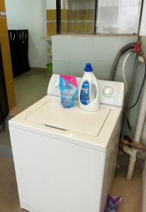 Una lavadora con dos botellas de detergente encima. en Habitación en Quito Centro, en Quito