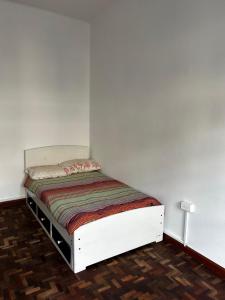 Un dormitorio con una cama blanca en una habitación. en Habitación en Quito Centro, en Quito