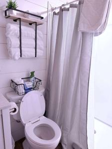 Un baño con una cortina de ducha blanca y un inodoro. en Tall Timber, en Packwood
