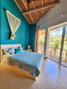 a bedroom with a bed with a blue wall at Belika Beach in Hiriketiya