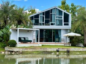 una casa con un lago di fronte di Villa At On Organic Farm a Ban Wak