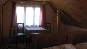 a bedroom with a window and a table and chairs at Chalupa Pribylina in Pribylina