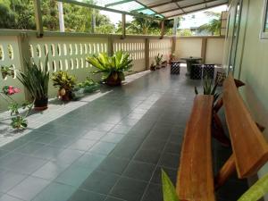 a porch with a bench and potted plants at บ้านชาร์มมิ่ง บางเสร่ Charming Bangsaray in Ban Nong Chaeng
