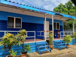 a blue house with blue chairs on the porch at T&T Koh Larn -เกาะล้าน in Ko Larn