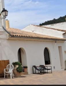 un edificio bianco con tavoli e sedie di fronte di Alojamiento Rural Ensueño Studio a Alcublas