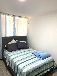 a bedroom with a bed with blue pillows on it at Comfort and an excellent area in Venezuela in Maracaibo