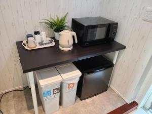 a black table with a microwave and some trash at Greci Art Tokyo グレーチアート東京 in Tokyo